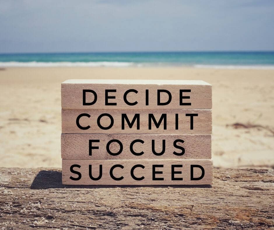 Boards on a beach with words "Commit to Succeed"
