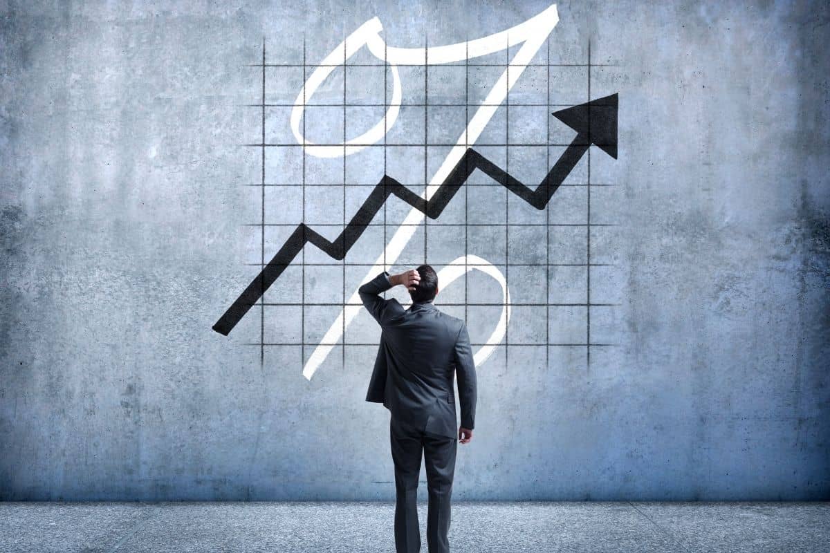 Man starting a graph with upward arrow and percentage sign
